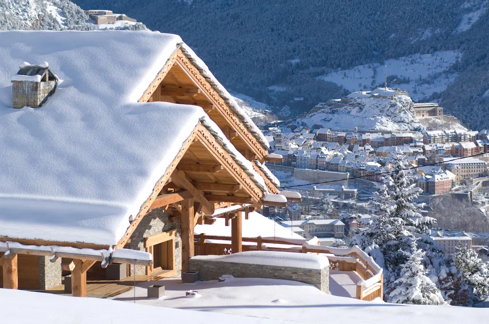 Toit du chalet enneigé dominant la ville de Briançon et la vallée